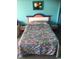 Bright bedroom with colorful bedding and matching end tables with a view of a partial sofa at 6803 N Ocean Blvd. # 210, Myrtle Beach, SC 29572
