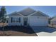 Gray house with a two-car garage and landscaping at 7207 Meadow Walk Loop, Loris, SC 29569