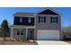 Two-story house with gray and dark gray siding, white garage door, and landscaping at 7303 Meadow Walk Loop, Loris, SC 29569