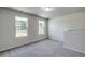 Bright bedroom featuring neutral walls, carpet, and two windows offering verdant backyard views at 109 Arrow Wood Dr, Conway, SC 29526
