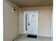 Front door of condo featuring side window and neutral siding with black door mat at 1095 West Plantation Dr. # 28-I, Little River, SC 29566