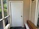 Porch area with a white door, tan siding, and a wooden bench at 1095 West Plantation Dr. # 28-I, Little River, SC 29566