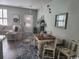Open-concept dining area with rustic table set on a blue rug next to living room featuring comfortable seating at 2256 Heritage Loop # 2256, Myrtle Beach, SC 29577