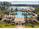 Aerial view of a large resort-style pool with palm trees and lake view in a community at 2256 Heritage Loop # 2256, Myrtle Beach, SC 29577