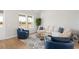 Bright living room boasting a white sectional sofa, stylish blue armchairs, and ample natural light from windows at 2469 Campton Loop, Conway, SC 29527