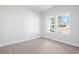 This bright bedroom boasts carpet flooring and a window view of a tree-lined street at 2480 Campton Loop, Conway, SC 29527