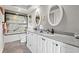 Bathroom with double sinks, white cabinets, mirrors, and a glass-enclosed shower, offering modern comfort at 100 Ocean Creek Dr. # L5, Myrtle Beach, SC 29572