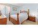 Light and airy bedroom with a wooden frame bed, side table and window at 100 Ocean Creek Dr. # L5, Myrtle Beach, SC 29572