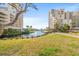 Scenic view of two buildings separated by a waterway and lush greenery, enhancing the serene landscape at 100 Ocean Creek Dr. # L5, Myrtle Beach, SC 29572