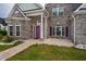 Inviting front entrance showcasing a brick facade, vibrant purple door, and manicured landscaping at 2207 Wood Stork Dr., Conway, SC 29526