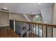 Upper loft area features hardwood flooring, metal railing and view to a windowed fireplace below at 2207 Wood Stork Dr., Conway, SC 29526