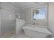 Bright bathroom featuring a soaking tub, walk-in shower, stylish tile work, and a scenic window view at 3788 Waterford Dr., Myrtle Beach, SC 29577