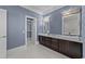Bathroom featuring double sinks with dark wood cabinets, vanity lighting, and a walk-in closet at 3788 Waterford Dr., Myrtle Beach, SC 29577