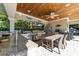 Covered outdoor kitchen boasts stainless steel appliances, a granite countertop bar, and a dining area for alfresco meals at 3788 Waterford Dr., Myrtle Beach, SC 29577