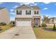 Charming two-story home featuring a blue front door, a brick-accented facade, and a spacious two-car garage at 568 Affinity Dr., Myrtle Beach, SC 29588