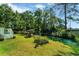Green backyard overlooking tranquil pond, featuring lush landscaping and mature trees at 1305 Conifer Ct., Murrells Inlet, SC 29576