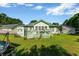 Serene backyard with deck, potted plants, lush lawn, and mature trees creating shade at 1305 Conifer Ct., Murrells Inlet, SC 29576