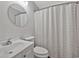 Cozy bathroom featuring a round mirror, patterned shower curtain, and white fixtures at 1305 Conifer Ct., Murrells Inlet, SC 29576