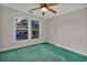 Bright bedroom featuring a ceiling fan, green carpet, and large window overlooking greenery at 1305 Conifer Ct., Murrells Inlet, SC 29576