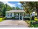 Charming single-story home featuring a cozy porch, green shutters, and well-manicured landscaping at 1305 Conifer Ct., Murrells Inlet, SC 29576