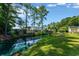 Backyard view showcasing a peaceful pond surrounded by trees and a verdant lawn at 1305 Conifer Ct., Murrells Inlet, SC 29576