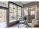 The light-filled sunroom includes walls of windows, tile flooring, a sliding glass door, and comfortable seating at 138 Sugar Loaf Ln., Murrells Inlet, SC 29576