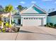 Charming, light blue home featuring an attached garage and a well-manicured front yard with lush tropical landscaping at 1604 Carsens Ferry Dr., Conway, SC 29526
