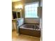 Bathroom featuring a tub with tile surround, vanity, and large window at 323 Sea Turtle Dr., Myrtle Beach, SC 29588