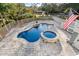 Aerial view of a uniquely shaped pool and spa with a waterfall and beautiful brick pavers at 437 N Boyle Dr., Pawleys Island, SC 29585