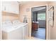 Bright laundry room featuring a washer and dryer, storage cabinets, and access to the living room at 538 Calhoun Dr., Murrells Inlet, SC 29576