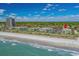 Coastal view showcasing beachfront condos, shoreline and community amenities under a blue sky with wispy clouds at 5601 N Ocean Blvd. # E-316, Myrtle Beach, SC 29577