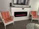 Cozy living space with electric fireplace, mounted TV, and comfortable wicker chairs for relaxing by the fire at 5601 N Ocean Blvd. # E-316, Myrtle Beach, SC 29577