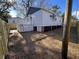 Backyard view with ladder to small deck, brick and dark painted foundation, with new privacy fence installation at 108 N Hazard St., Georgetown, SC 29440