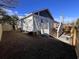 Backyard view of the home featuring white exterior, a small deck with access stairs, and recently installed fencing at 108 N Hazard St., Georgetown, SC 29440