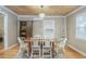 Well-lit dining room with a wooden table, white chairs, and view into the kitchen at 108 N Hazard St., Georgetown, SC 29440