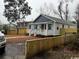Home's exterior shows fresh paint, landscaping, and a new fence for added privacy at 108 N Hazard St., Georgetown, SC 29440