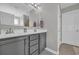 A modern bathroom featuring dual sinks, gray cabinets, a large mirror, and updated lighting fixtures at 217 Astoria Park Loop, Conway, SC 29526