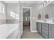 Bathroom with soaking tub and double sink vanity leading to bedroom with canopy bed at 217 Astoria Park Loop, Conway, SC 29526