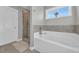 A bright bathroom boasting a soaking tub, glass enclosed shower, and a window providing natural light at 217 Astoria Park Loop, Conway, SC 29526