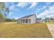Rear view of the house showing the porch in the backyard with some sparse woods at 240 Palmetto Sand Loop, Conway, SC 29527