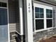 Close-up of a home's exterior showing the house number, gray siding, stone accents, and trim on the windows at 240 Palmetto Sand Loop, Conway, SC 29527