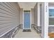 Close up shot of home's front door with gray siding and stacked stone details at 240 Palmetto Sand Loop, Conway, SC 29527