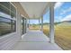 A covered back porch featuring white columns, a concrete floor, and views of the backyard at 240 Palmetto Sand Loop, Conway, SC 29527