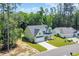 Aerial view of a two-story home with a spacious lawn, long driveway, and lush green trees surrounding the property at 604 Mccown Dr., Conway, SC 29526