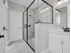 Modern bathroom featuring white marble tile, glass enclosed shower with black trim, and sleek fixtures at 604 Mccown Dr., Conway, SC 29526