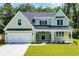 Charming two-story home featuring a covered porch, black metal roof, and attached two-car garage at 604 Mccown Dr., Conway, SC 29526
