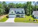 Charming two-story home featuring a covered porch, black metal roof, attached garage, and well-manicured lawn at 604 Mccown Dr., Conway, SC 29526