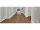 Hallway featuring hardwood floors, white trim and baseboards, leading to a living area with a ceiling fan at 604 Mccown Dr., Conway, SC 29526