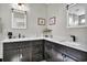 Modern bathroom features dual sinks with dark cabinets, a marble countertop, and stylish fixtures at 253 W Second Ave. S, Ocean Isle Beach, NC 28469