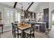 An open floor plan showcasing dining area flows into a modern kitchen with barstool seating and wood beam at 253 W Second Ave. S, Ocean Isle Beach, NC 28469